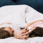 couple-holding-hands-bed_23-2148027351